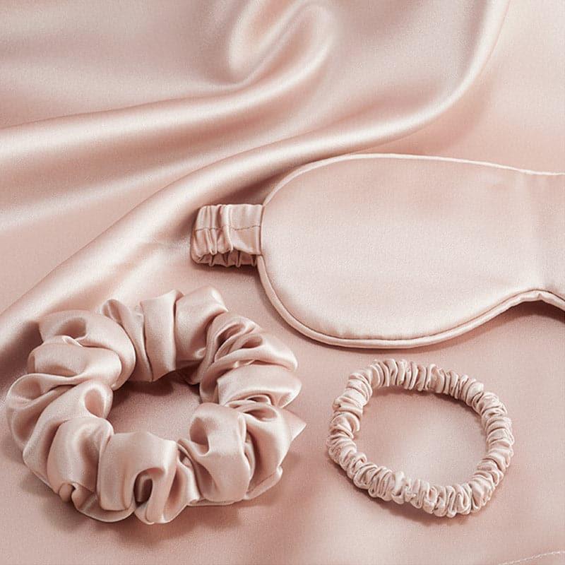 Champagne silk eye mask and scrunchies from the DAISYSILK travel set on silk fabric