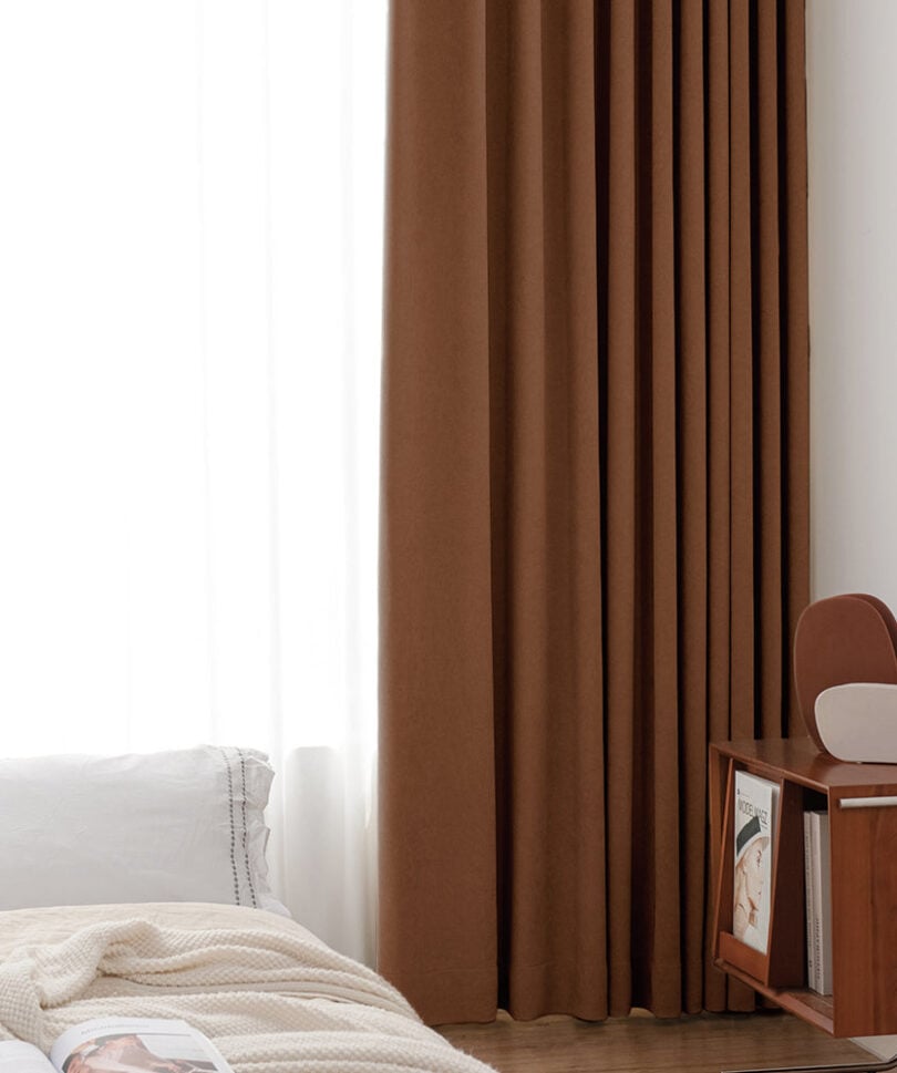 Rust-brown Homerilla Harmonia blackout curtains beside a bed