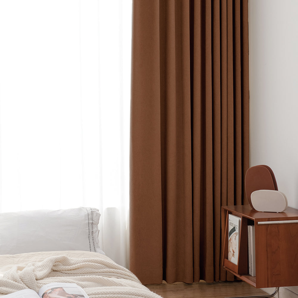 Rust-brown Harmonia blackout curtains beside a bed
